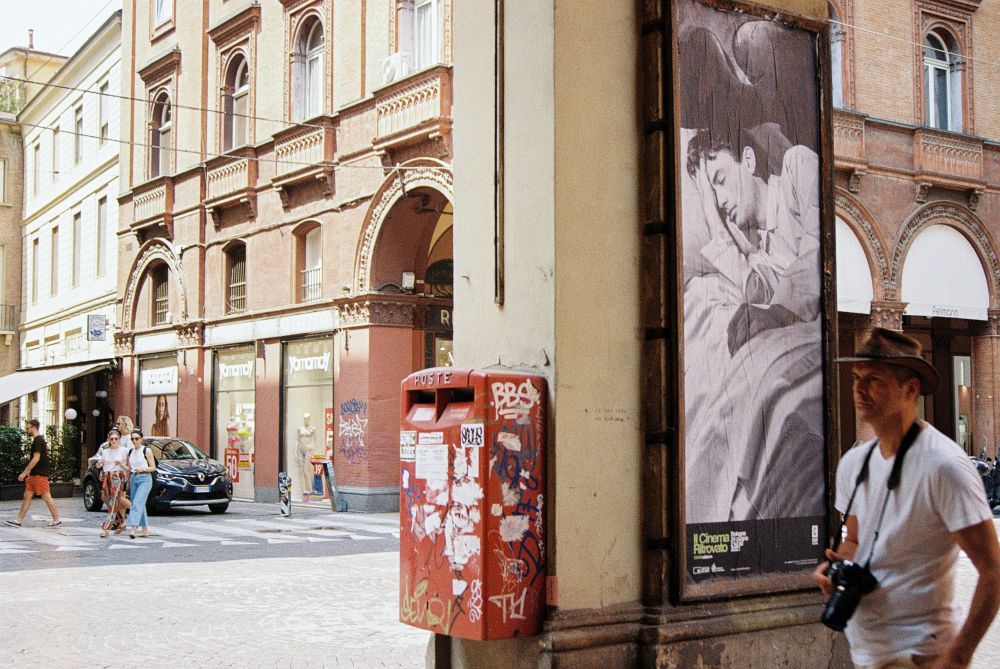Mann mit Cowboyhut und Kamera in Bologna