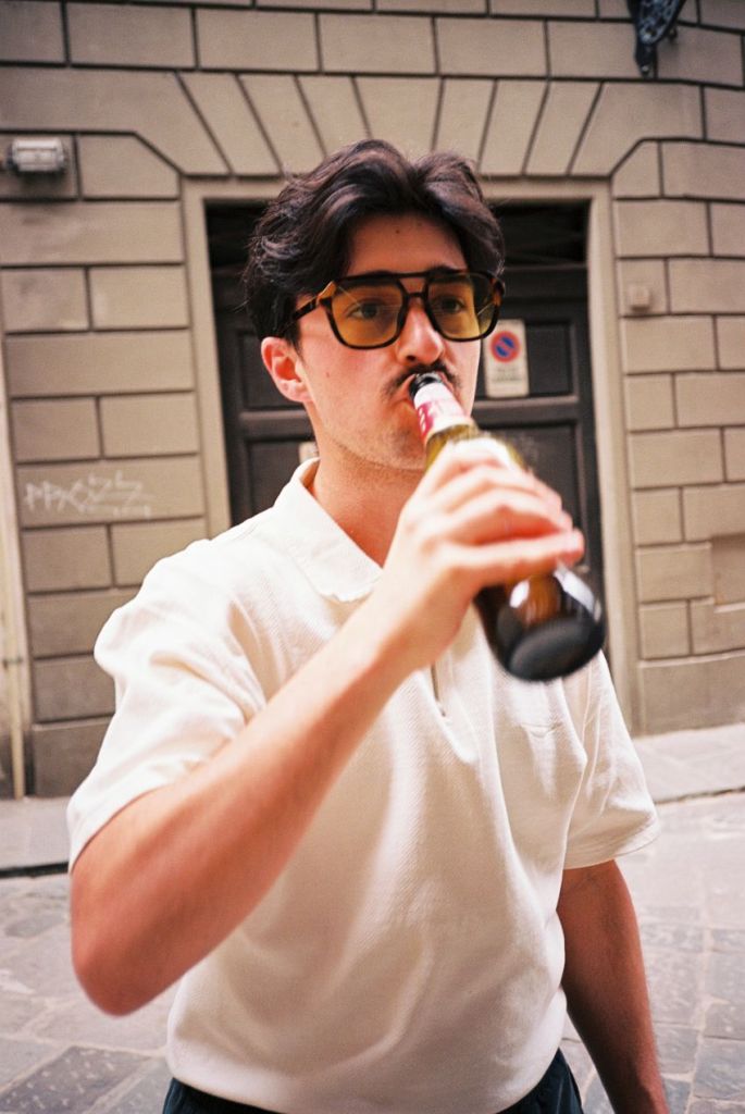 Mann mit Sonnenbrille, der aus einer Bierflasche trinkt